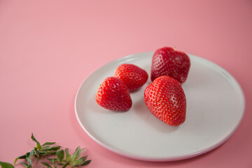Delicious juicy ripe red strawberries on a pink background. Close-up shot of strawberries on a grater. Macro shot of garden strawberry
