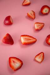 Delicious juicy ripe red strawberries on a pink background. Close-up shot of strawberries on a grater. Berry pattern