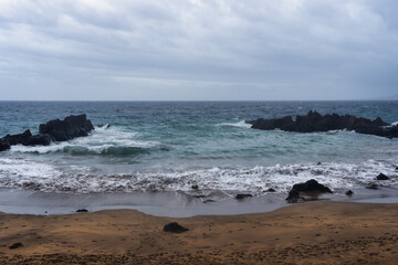 Fototapeta na wymiar waves on the beach with rocks