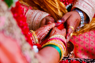 Hands of bride is decorated beautifully by indian mehndi art along with jewelery’s and colorful bangles
