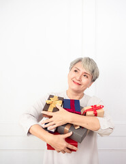 Senior asian woman holding mount of gift boxes, enjoying many best presents.