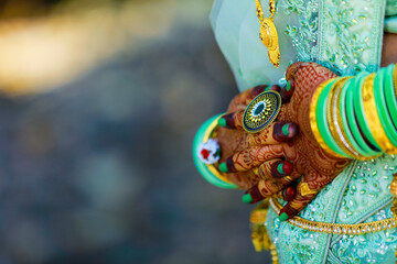 Hands of bride is decorated beautifully by indian mehndi art along with jewelery’s and colorful bangles