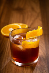 Negroni cocktail with orange, on wooden background.