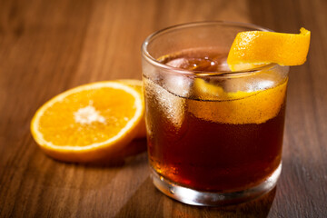 Negroni cocktail with orange, on wooden background.