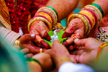 groom and bride holding green leaf and lord Ganesha sculpture in hand