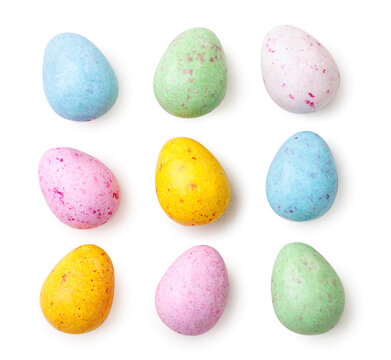 Small speckled multicolored chocolate eggs set on a white background, isolated. Top view