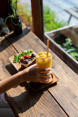Iced fresh mango smoothies glass and Fruit cake decorated with figs on plate wooden