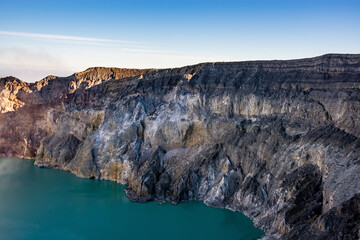 Ijen volcano crater with lake and sulphur mining. Beautiful Landscape mountain and green lake with smoke sulfur in the morning in a Kawah Ijen volcano. Beautiful landmark from East Java, Indonesia