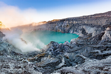 Ijen volcano crater with lake and sulphur mining. Beautiful Landscape mountain and green lake with smoke sulfur in the morning in a Kawah Ijen volcano. Beautiful landmark from East Java, Indonesia