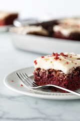 Close up of a red velvet chocolate brownie square ready for eating with other brownies in soft...
