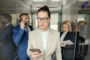 Office employees working in elevator