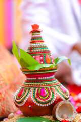 Indian wedding ceremony : decorative coper kalash with green leaf and coconut