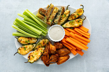 Top down view of an appetizer platter filled with homemade baked appetizers and crispy cold celery...