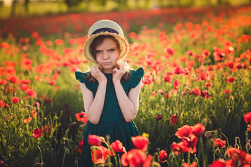 Girl in dress and straw hat outdoor At Poppy Field