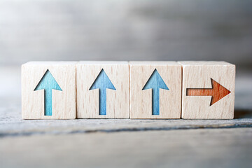 Arrows With Different Directions On Wooden Blocks On A Board - Standing Out From The Crowd Concept