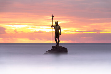 God Neptune among smooth waters at Melenara Beach (Spain) at sunrise