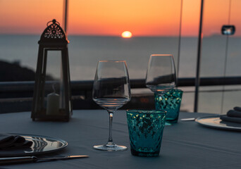 Two wine glasses and glasses served on a sunset background