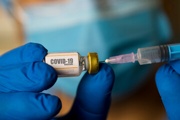 Doctor preparing injection with covid-19 vaccine at hospital