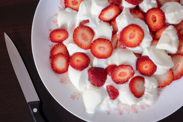 Plato con fresas con nata y cuchillo para cortar las fresas