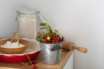 Baking pie dish and fresh cherry on wooden table