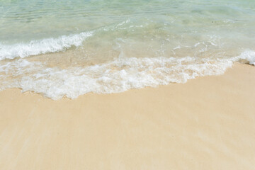 Fototapeta na wymiar Soft wave of sea on empty sandy beach Background with copy space.