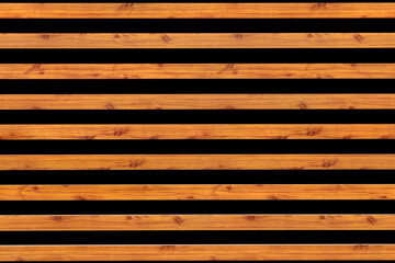 The background is the texture of horizontal planks saturated orange color with black space between them geometry and lines fashionable modern wall of wood and wooden building materials and lumber.