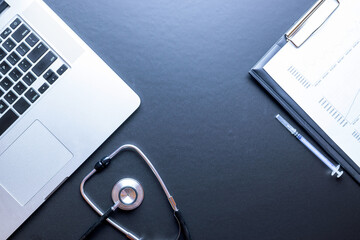 Doctors office. Stethoscope, hospital healthcare infographic charts and medical syringe, notebook on dark background. Health care, insurance and help concept.