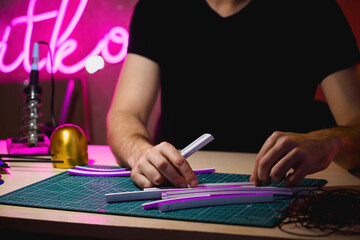 Cropped view of craftsman holding flex neon tear tools in workshop 