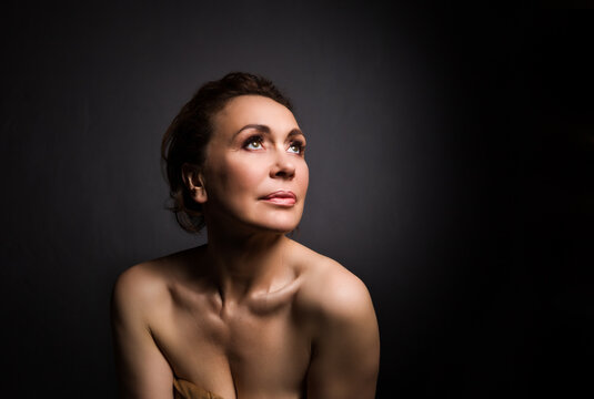 portrait of a sensual fifty year old woman on grey studio background
