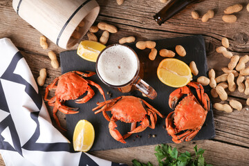 Mug of beer with crabs on a wooden surface