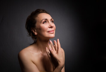 Fototapeta premium portrait of a sensual fifty year old woman on grey studio background