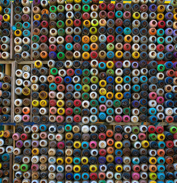 Large Number Of Used Colorful Spray Cans Of Aerosol Paint Lying On The Treated Wooden Surface. Abstract Multicolored Background Made From Old Used Bottles Of Spray Paint. Creative Concept For Design. 