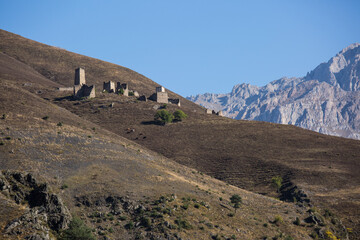 Landscape autumn view of medieval ancient stone battle tower complex in the mountains of Ingushetia, Russia