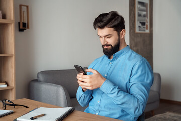 Millennial freelance businessman take break during workday using mobile phone