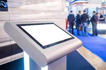 Deurstickers Electronic multimedia kiosk with blank white display at exhibition, trade show, conference - close up view. Mock up, futuristic, corporate, copyspace, template, white screen, technology concept © zyabich