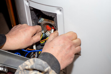 The foreman disassembled the electric boiler for repair and maintenance. Heater control relay
