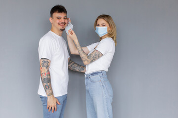 Man and woman wearing face mask standing from each other keeping social distancing avoiding physical contact, infection and the spread of coronavirus. COVID-19 health protocols and New Normal.