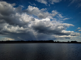 WIDOK NA JEZIORO. POCHMURNY DZIEŃ NAD JEZIOREM. CZAS WIOSNY.