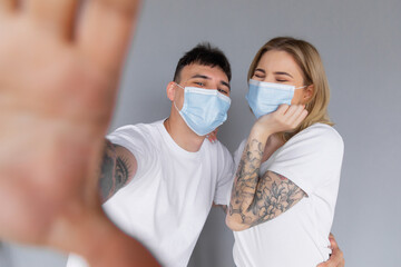 Close up photo of two people spouses make selfie blogging healthcare cov infection epidemic protection sit comfort couch wear medical mask in house indoors