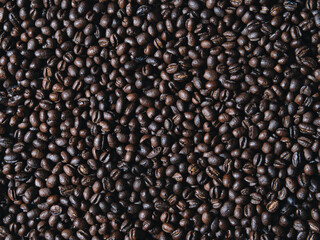 Roasted coffee beans on a flat background.