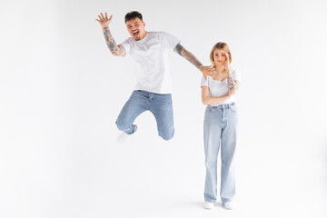 Full-length photo of energetic couple man and woman in casual t-shirt running and smiling on camera with happy look isolated over white background