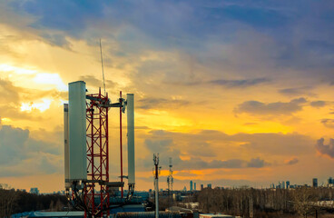 Mobile Phone Communication Antenna Tower With Silhouette In Sunset Sky Background