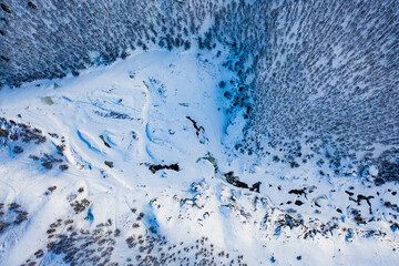 White frozen forest and river in winter. Aerial view of nature in Ural, Russia