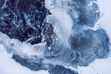 The holes in ice through which are visible the algae