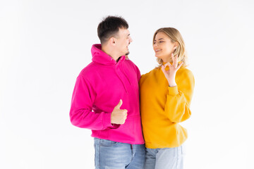 Portrait of excited enthusiastic couple promoters show thumb up recommend choice adverts hug wear color pullover good look isolated over white color background