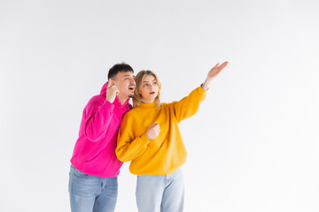 Portrait of cheerful people man and woman in basic clothing smiling and clenching fists like winners or happy people isolated over white background