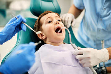 Little boy with mouth wide open during dental check-up at dentist's office.