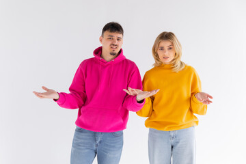 Image of happy young people man and woman in basic clothing throwing up arms with puzzlement isolated over white background