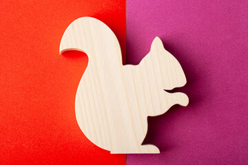 Squirrel figurine carved from solid pine by hand jigsaw. On a multi-colored background