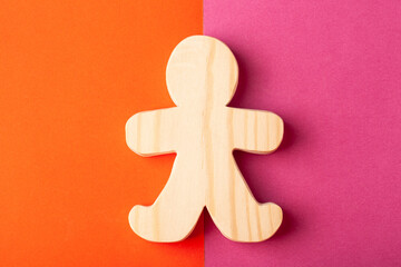 A figurine of a man carved from solid pine with a hand jigsaw. On a multi-colored background